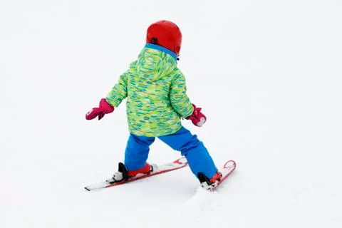 Small active child skiing on snow slope Foto stock