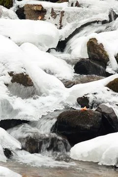 A small active waterfall. Clean mountain stream, snowy winter landscape Stock Photos