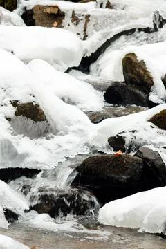 A small active waterfall. Clean mountain stream, snowy winter landscape Stock Photos