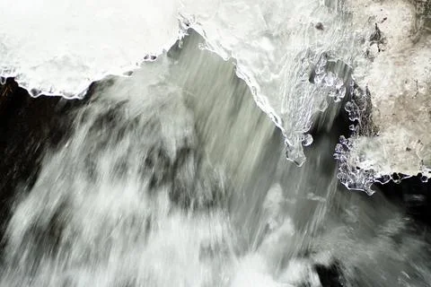 A small active waterfall. Clean mountain stream, snowy winter landscape Stock Photos