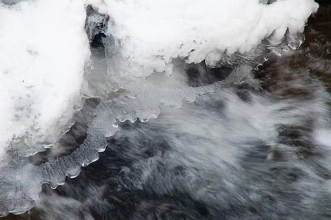 A small active waterfall. Clean mountain stream, snowy winter landscape Stock Photos