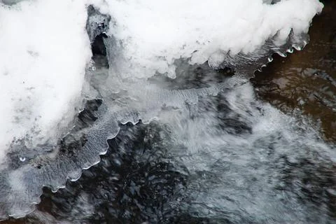 A small active waterfall. Clean mountain stream, snowy winter landscape Foto stock