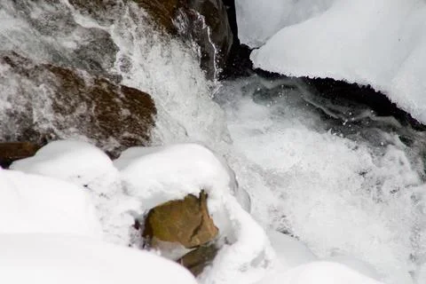 A small active waterfall. Clean mountain stream, snowy winter landscape Stock Photos