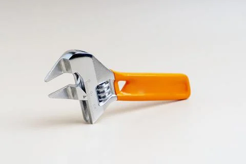 Small adjustable wrench with orange handle and size divisions Stock Photos
