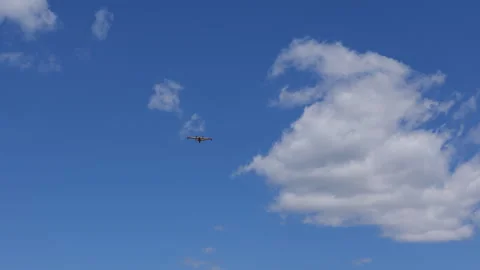 Small aircraft flying through blue sky with clouds on a clear day Stock Footage 326972945