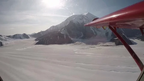 Small airplane flying between mountains in Alaska on a tourist expedition. Stock-Footage 127066146