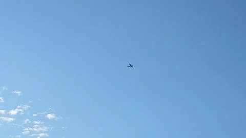 Small Airplane Flying High in a Clear Blue Sky 스톡 사진