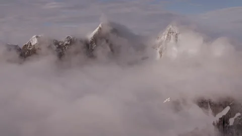 Small airplane flying over epic mountain peaks and clouds 스톡 동영상 335106925