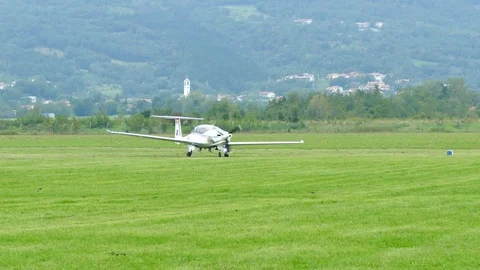 Small airplane on grassy landing zone Stock Footage 80959989