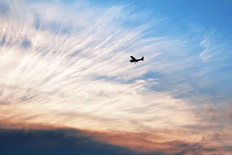 Small airplane silhouette in the sky at dramatic sunset Stock Illustration