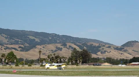 SMALL AIRPLANE TAKING OFF FROM A RUNWAY WITH PANNING MOTION 動画素材 63036848