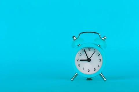 Small alarm clock on blue background Stock Photos