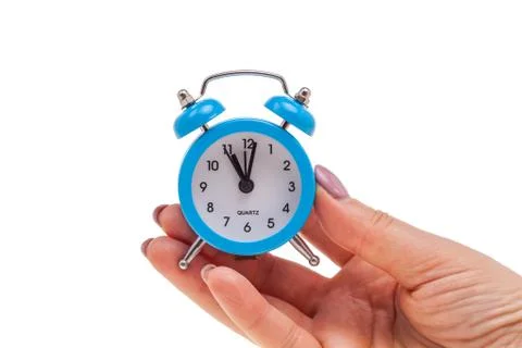 Small alarm clock in hand, concept of being in time Stock Photos