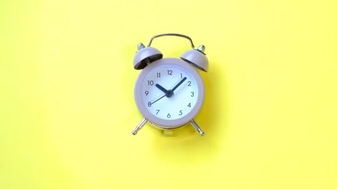 Small alarm clock on a yellow background close-up, top view. Stock Footage 294303780