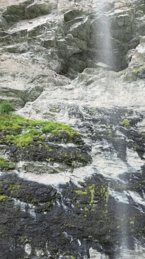 Small Alpine Waterfall Flowing Over Rocky Ledge – 4K Vertical Drone View Video stock 328706427