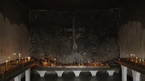 Small ancient Christian altar inside a mountain rock with burning church candles Stock Footage 284385171