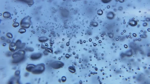 Small and big air bubbles in water rising in slow motion on blue background Stock Footage 131737452