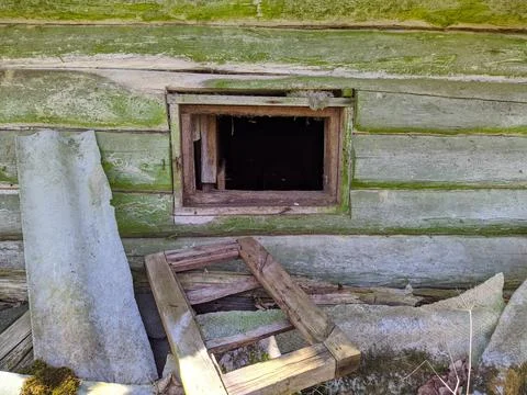 Small and broken window without glass of a wooden shed outside view Stock Photos