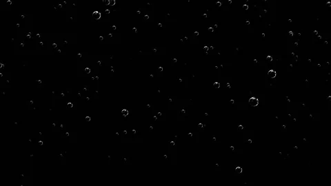 Small and large bubbles in a soda pop up against a black background. Stock Footage 151947668