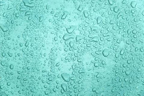Small and large drops of condensation on frosted colored glass Stock Photos