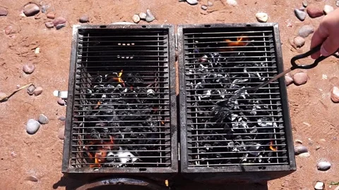 Small and old barbecue grill on sand beach with fire Stock Footage 264352791