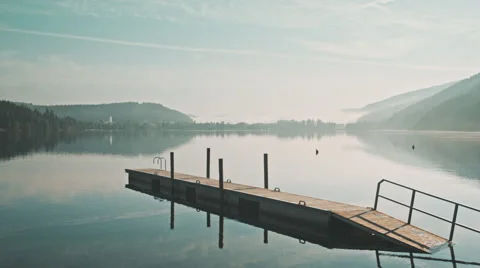 A small and old dock on a clear lake with Titisee  covered in fog. Video stock 63225080