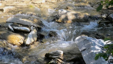 Small and shallow rocky river with rapids and waterfalls flows in the mountains Stock Footage 140091689