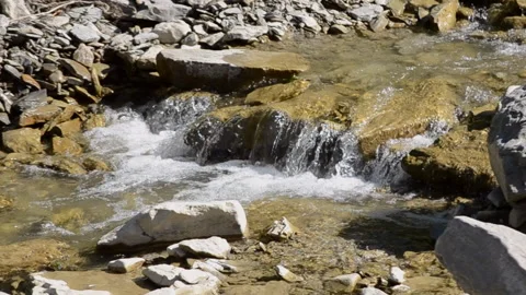 Small and shallow rocky river with rapids and waterfalls flows in the mountains Stock Footage 140091766