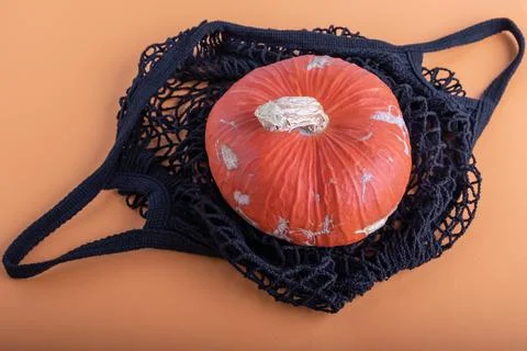 A small appetizing orange pumpkin of imperfect natural appearance in an open  Stock Photos