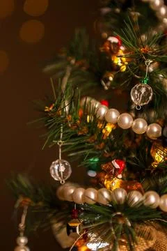 Small artificial Christmas tree decorated with lights and ornaments in a wa.. Fotos Stock