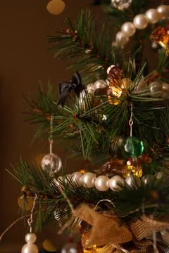 Small artificial Christmas tree decorated with colorful beads and ribbons f.. Photos