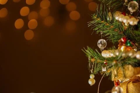 Small artificial Christmas tree decorated with ornaments and lights indoors.. Stock Photos