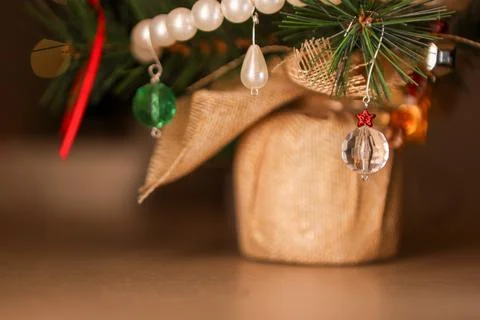 Small artificial Christmas tree decorated with ornaments and lights placed .. Stock Photos