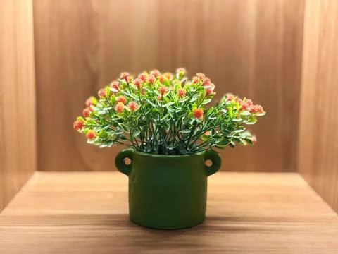Small artificial flowers with bright reddish-orange or salmon-pink blossoms Stock Photos
