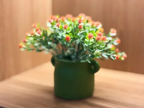 Small artificial flowers with bright reddish-orange or salmon-pink blossoms Stock Photos