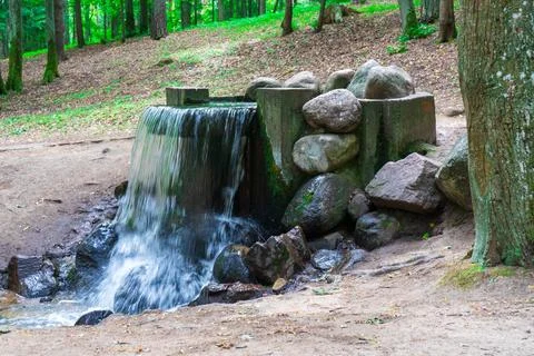 Small artificial waterfall in the park. Stock Photos