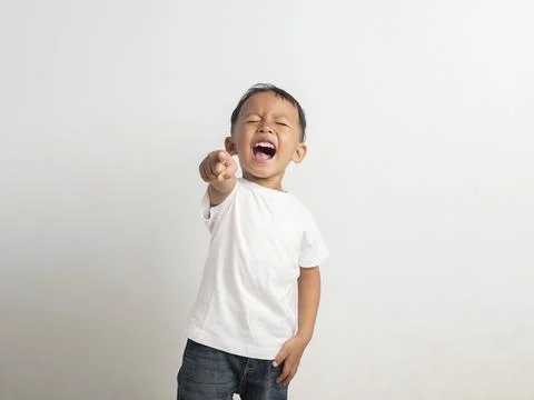 Small asian boy points his finger upward while shouting loudly with a wide .. Stock Photos