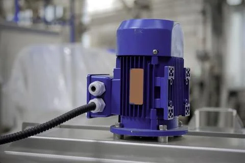 A small asynchronous electric motor mounted on equipment. Stock Photos