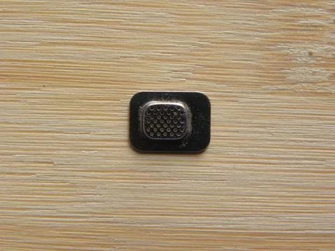 Small audio micro component of smartphone kept on wooden table Stock Photos