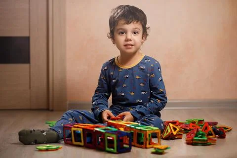 Small autistic boy plays with a construction kit. Stock Photos