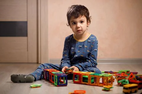 Small autistic boy plays with a construction kit. Stock Photos