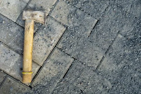 A small ax is placed on a paving block Stock Photos