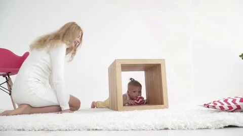Small baby boy playing inside the wooden cube in the room Stock Footage 73632300