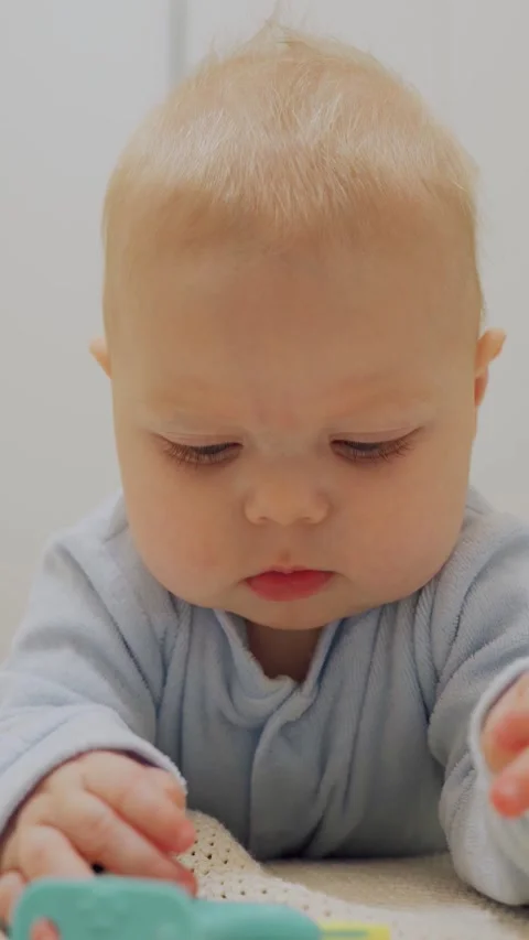 A small baby boy plays with a toy, His Stock Video Pond5