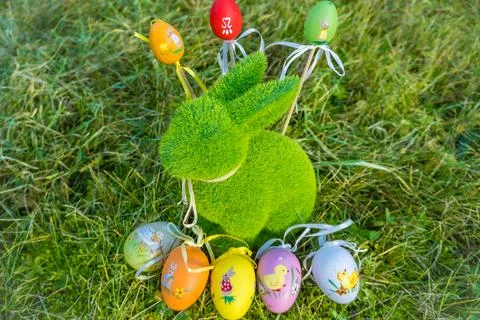 Small baby rabbit and easter eggs in the fresh, green spring landscape. Stock Photos
