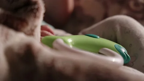 Small baby's hand playing with a toy in a bed 動画素材 233264976