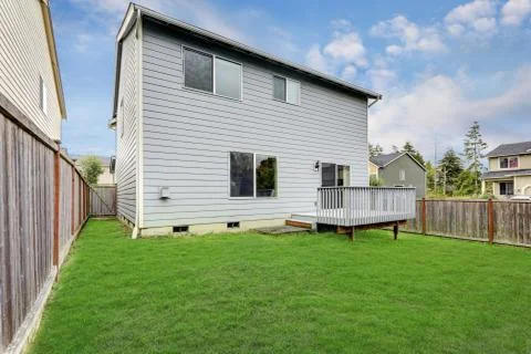 Small back yard with green grass and wooden fence. house exterior.  Northwest Stock Photos