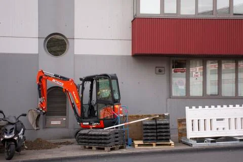 Small backhoe machinery stop working wait german people use build street road Stock Photos