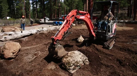 Small backhoe moving large rock Stock Footage 51746195