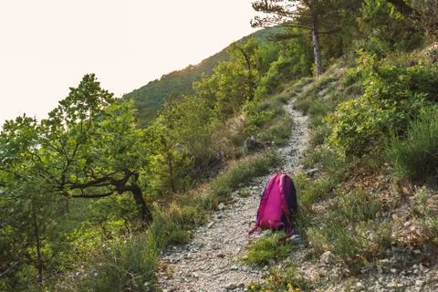 A small backpack on the ground on a hiking path in the French Alps during sun Stock Photos